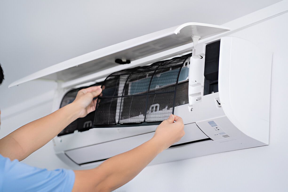 A person is cleaning the filter of an air conditioner.