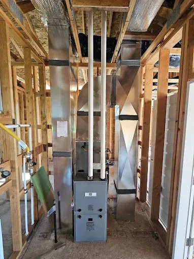 A heating and cooling system is being installed in a house under construction.
