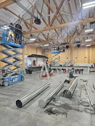 A large room with a lot of pipes being installed in it.