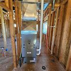 A picture of a furnace in a house under construction.
