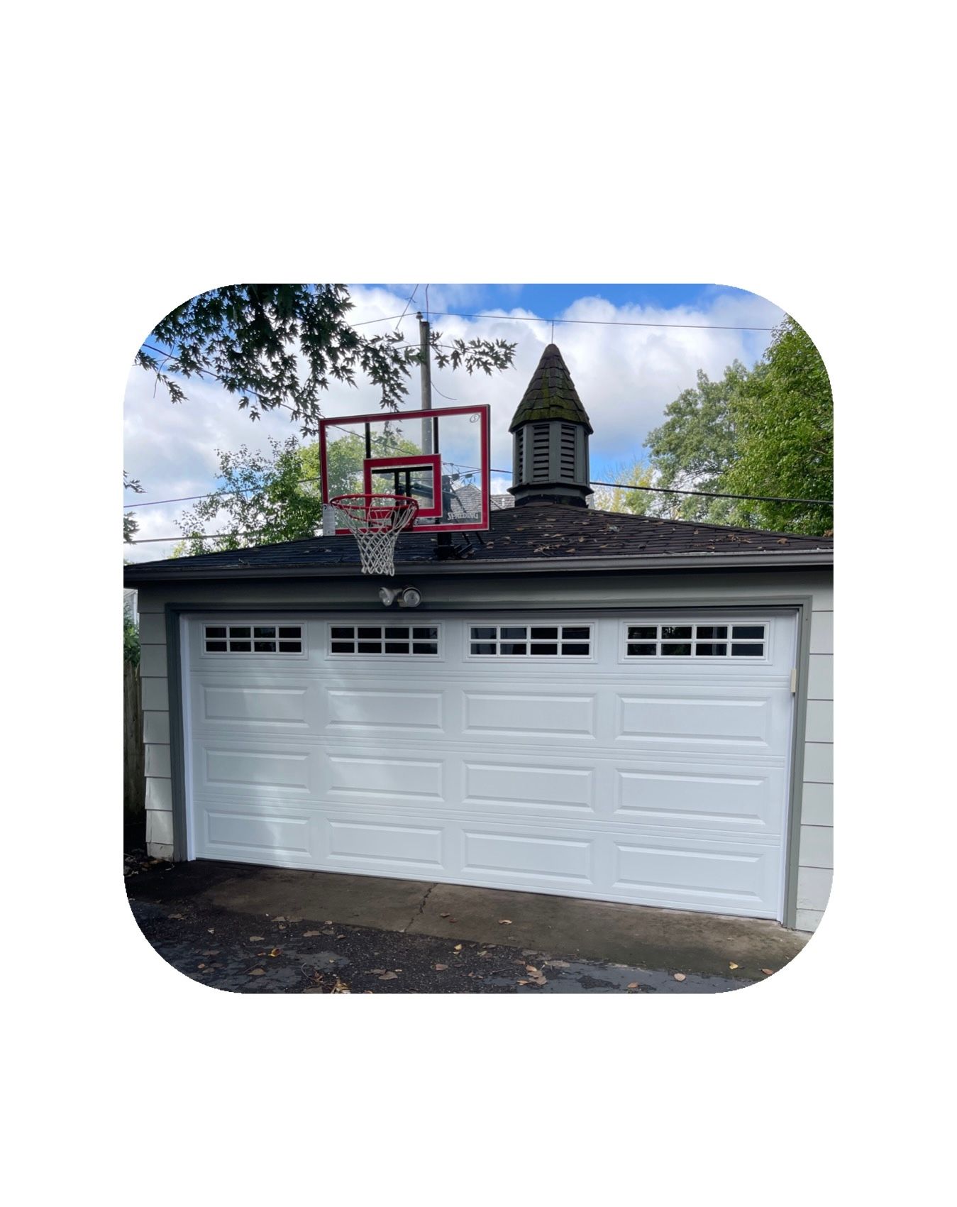 White garage with basketball hoop, chimney, and blue sky.