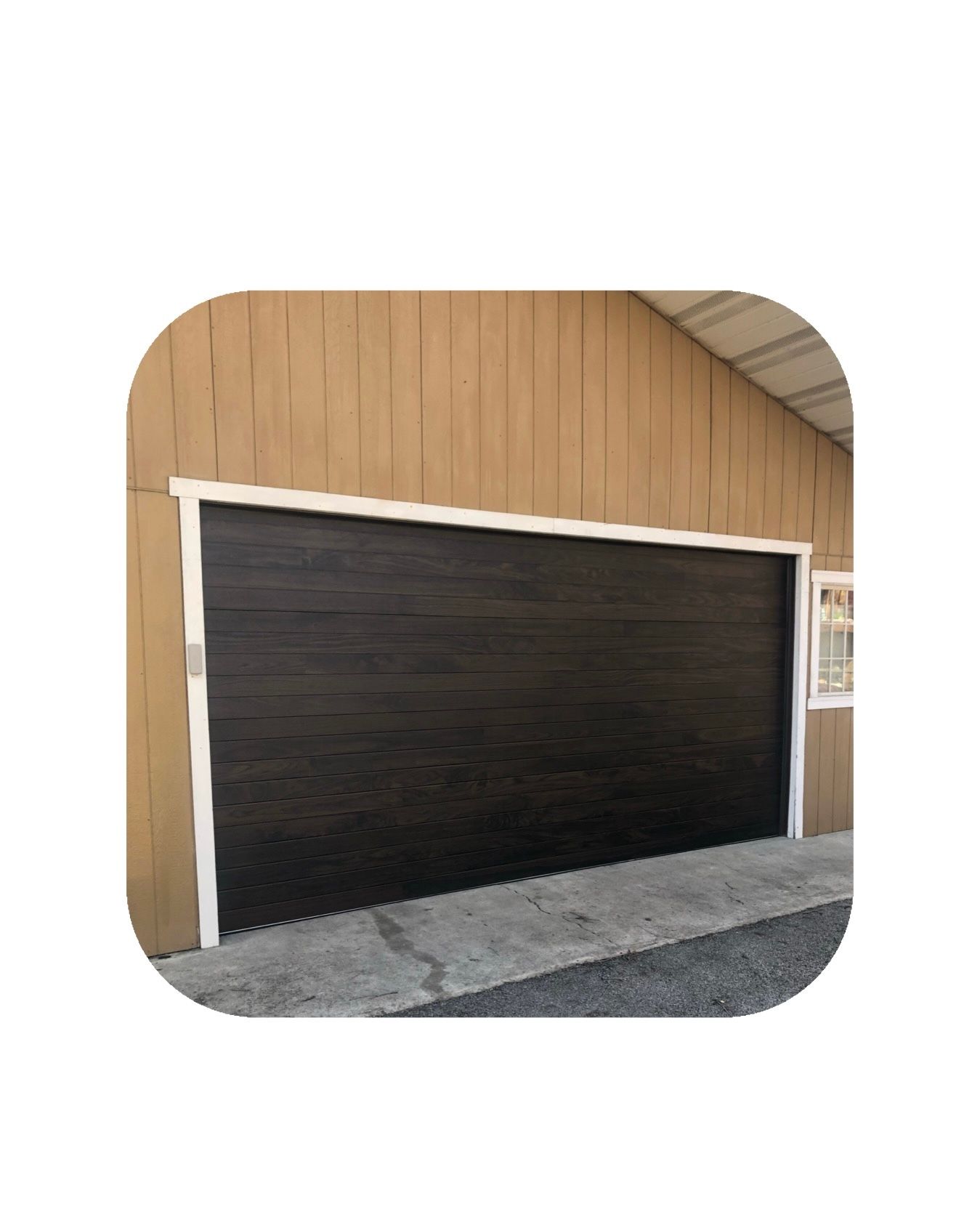 Brown garage door with white trim, on a light brown building.