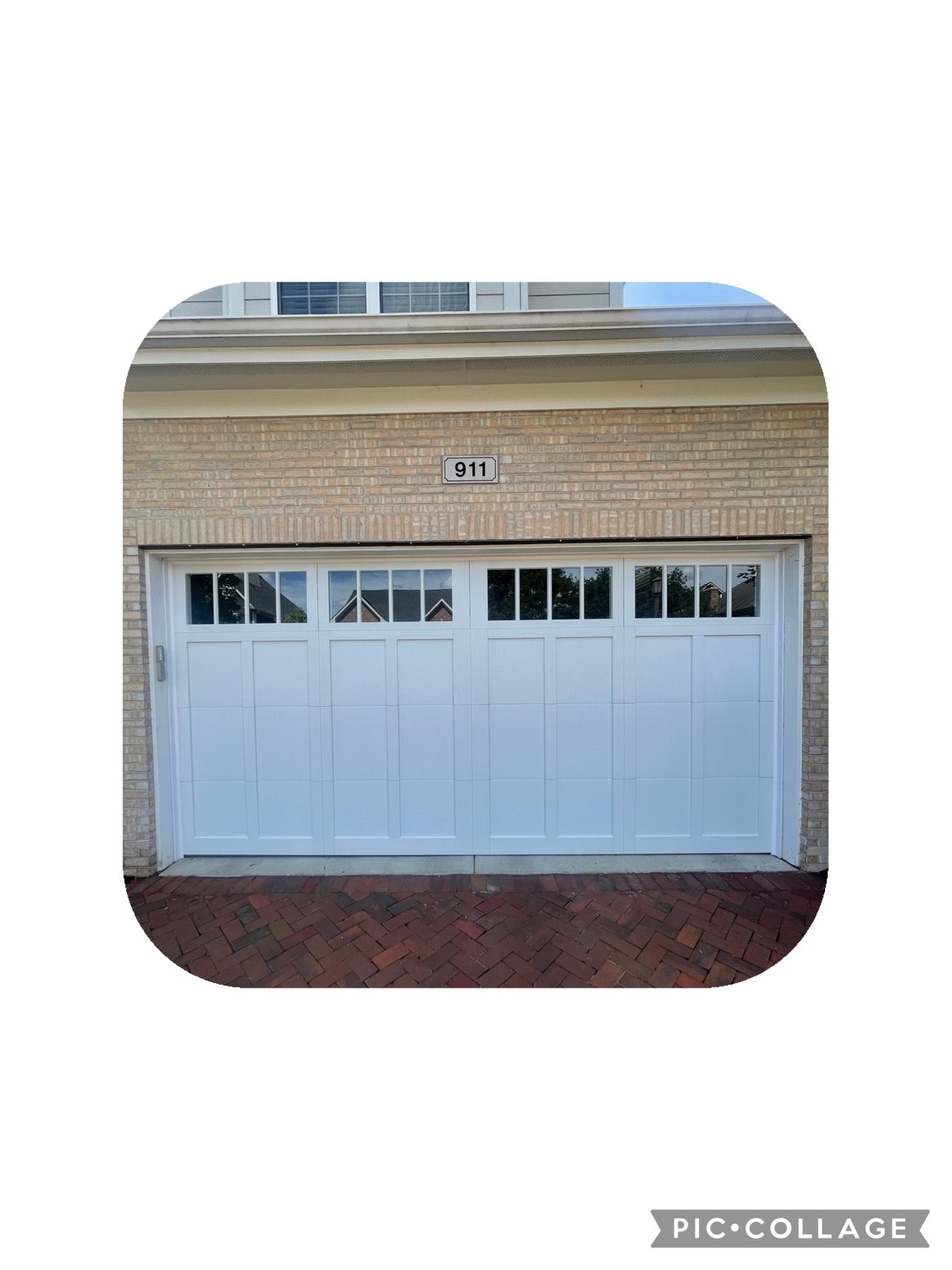 White garage door with glass panes, brick building exterior.
