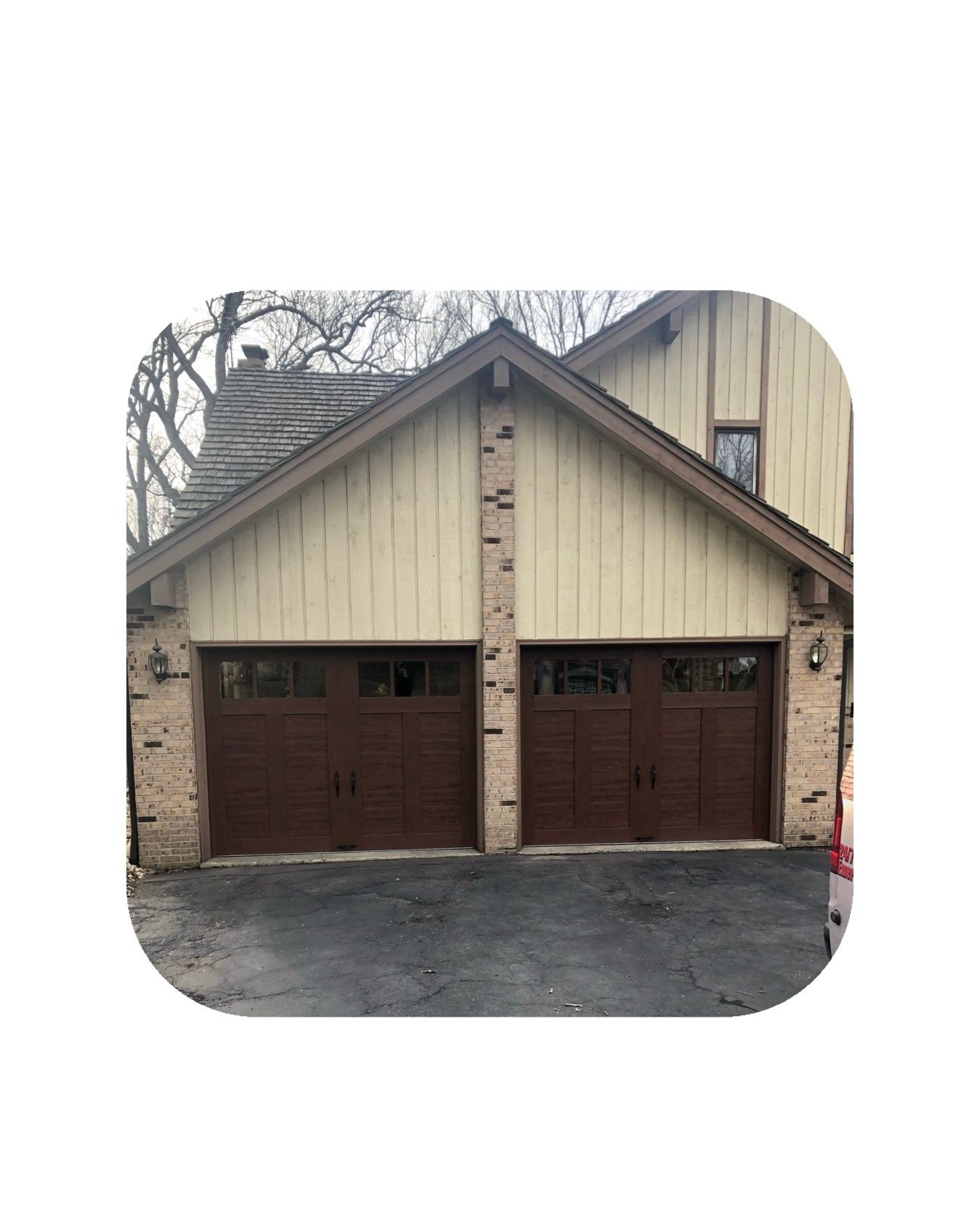 Brown double garage doors on a house with tan siding, and brick.
