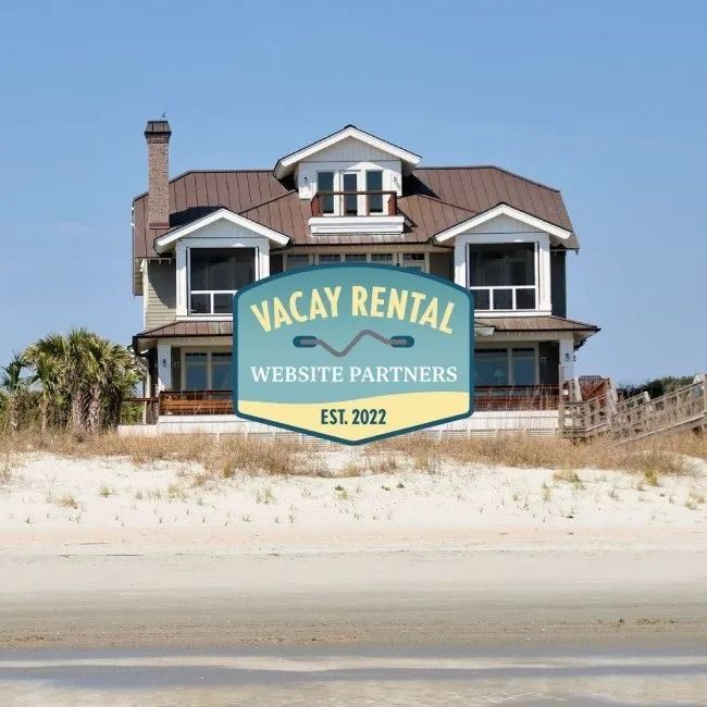 Beach house with a Vacay Rental logo overlayed on it. The house is gray and brown. A beach and blue sky are visible.