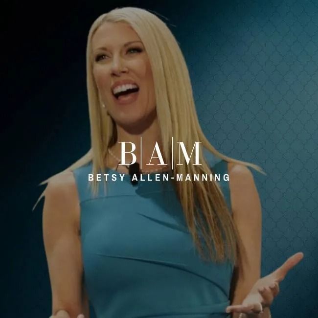 Betsy Allen-Manning, blonde woman in a blue dress, speaking with an open mouth and hands gesturing.