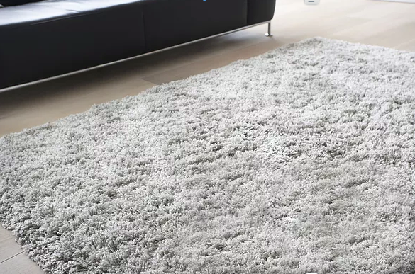 A kitchen with white cabinets and a rug on the floor