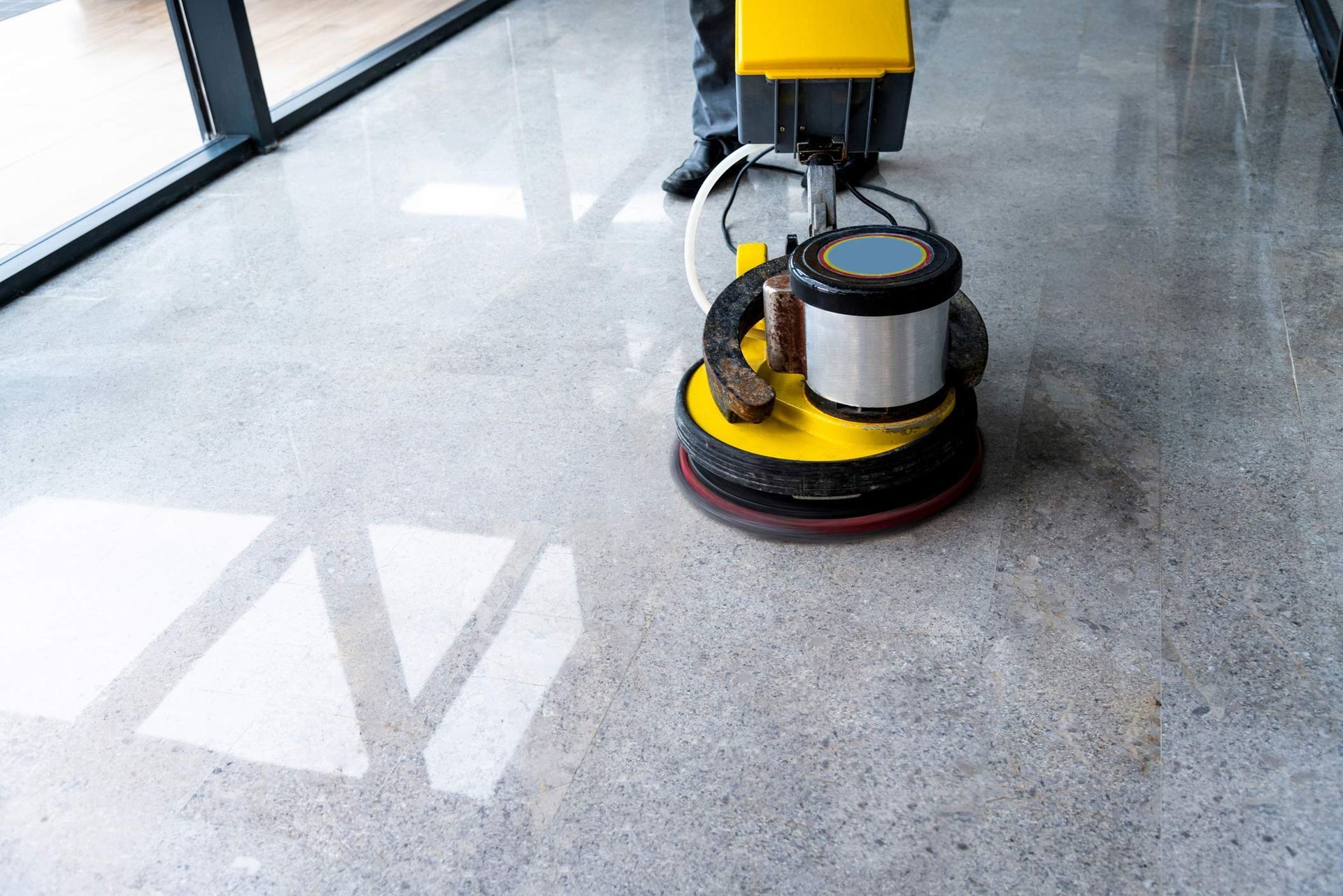 Worker marble polishing a floor in a modern office building.