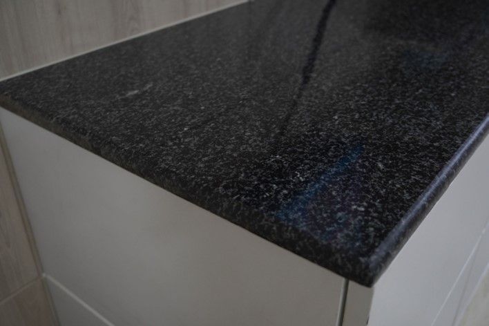 Close-up of a black granite countertop of a kitchen top.