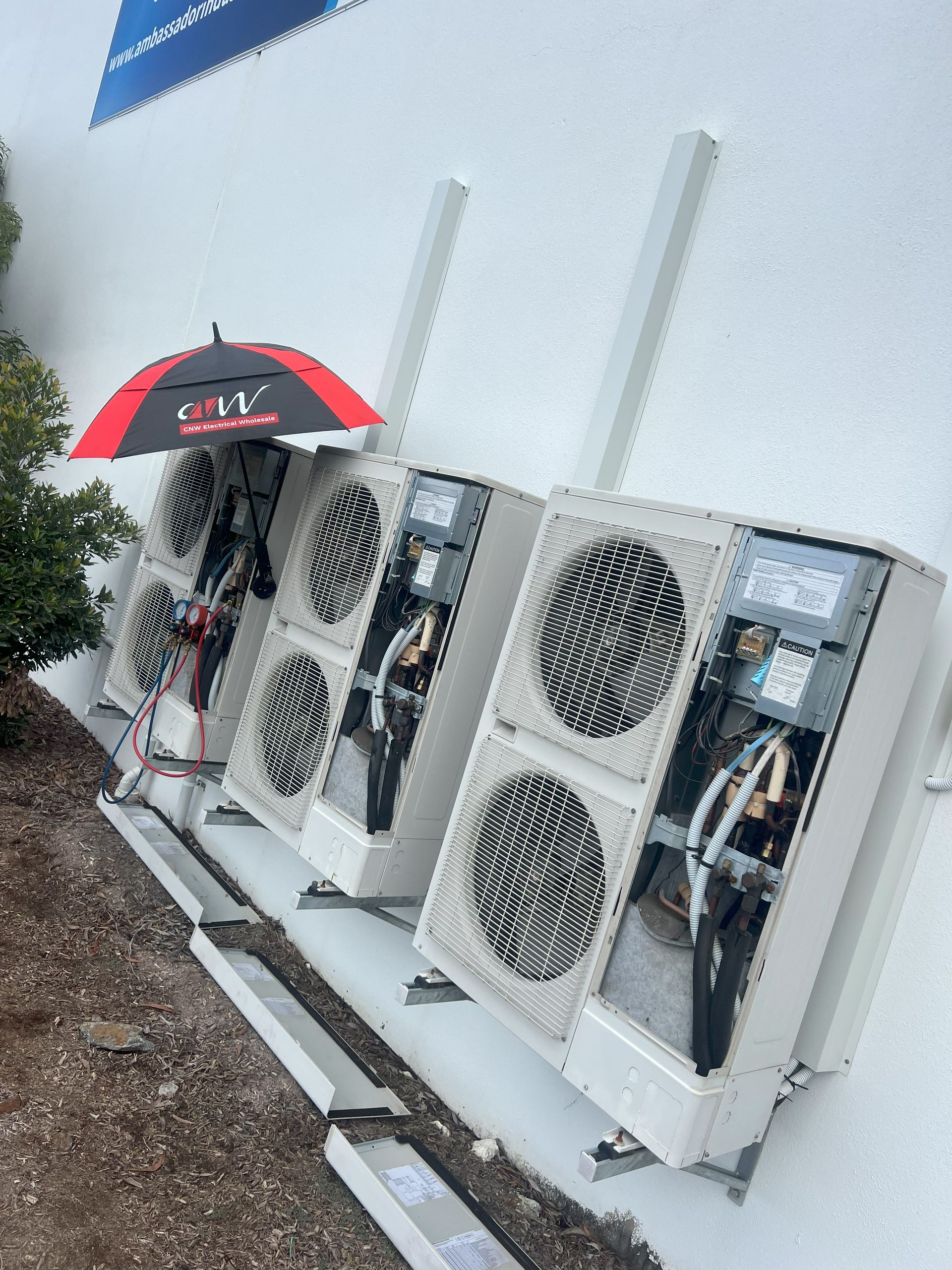 Air Conditioning Units Mounted on a White Building — NDR Trade Solutions in Robina, QLD