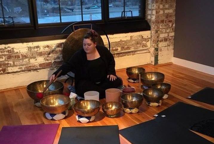 laina pilkenton playing singing bowls near yoga mats