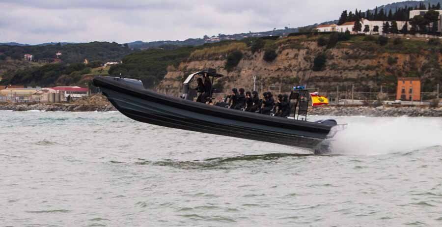 A large boat is speeding on top of a body of water.