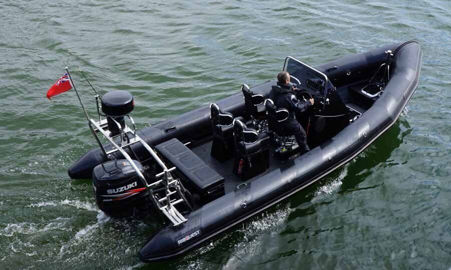 A large black boat is floating on top of a body of water.