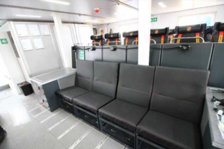 A row of black chairs are lined up in a room.