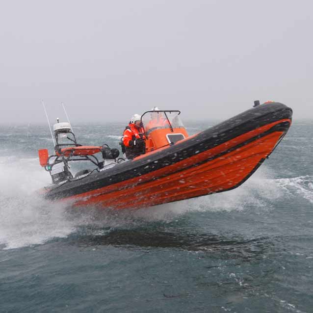 Gallery. An orange and black boat is floating on top of a body of water.