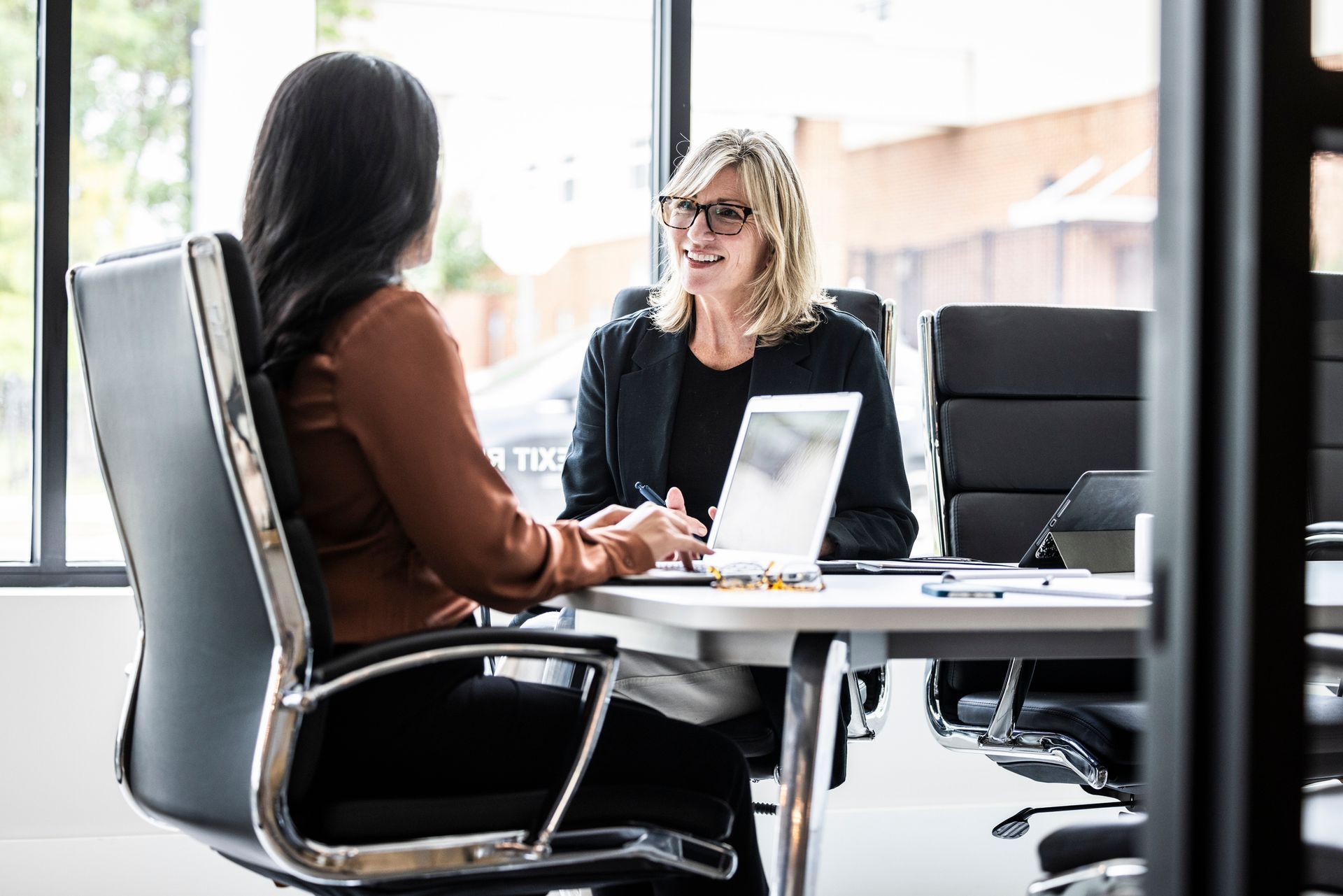 Two professionals discussing financial strategies at a modern office table.