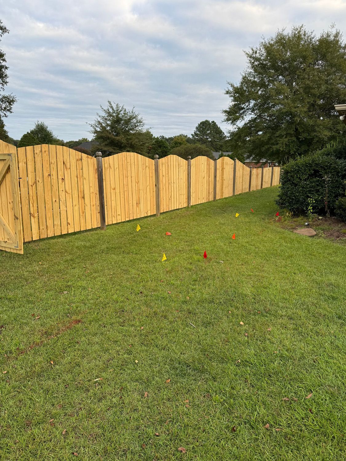 A wooden fence is sitting in the middle of a lush green field.