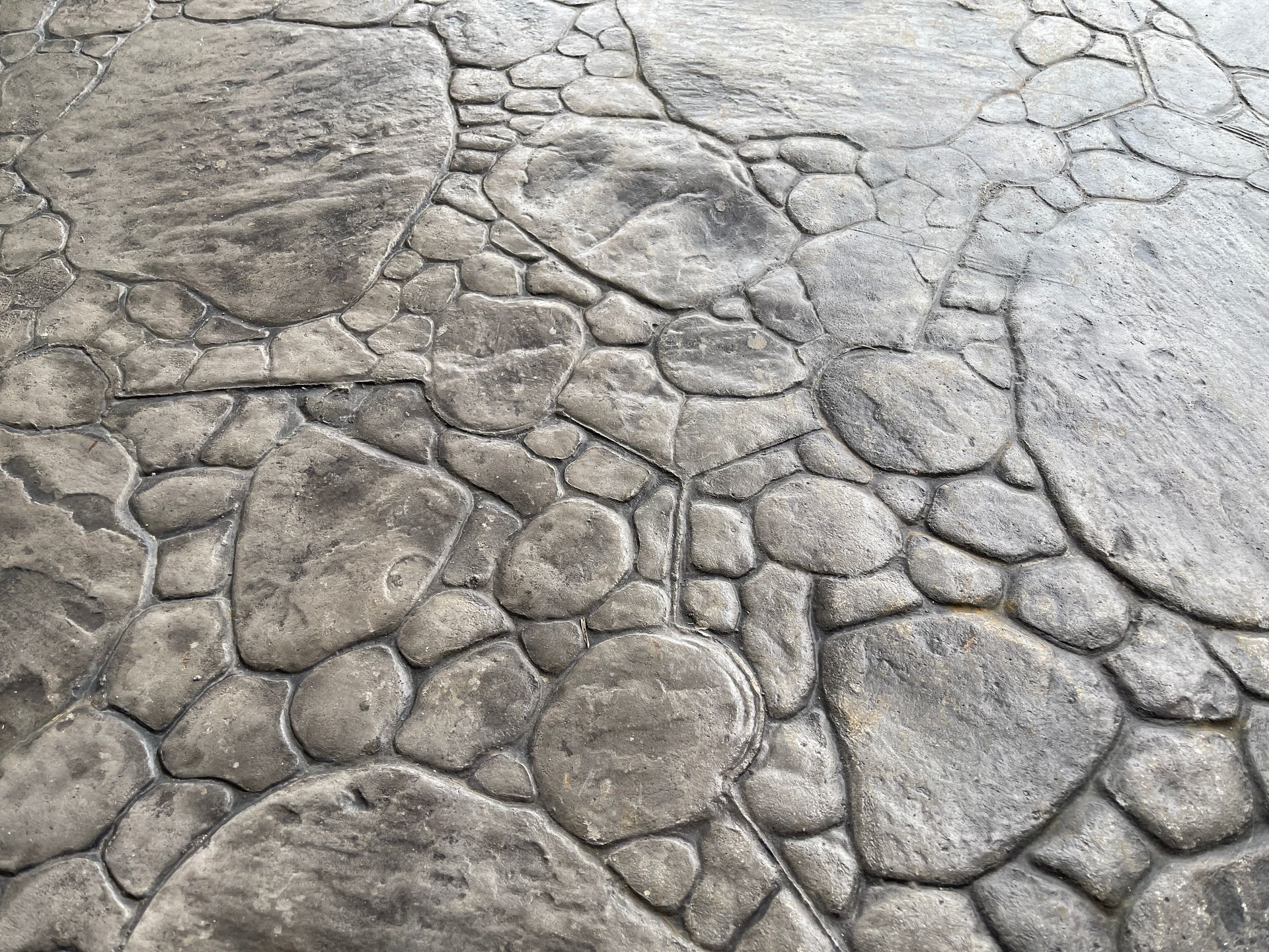 Gray stamped concrete patio with a cobblestone design.