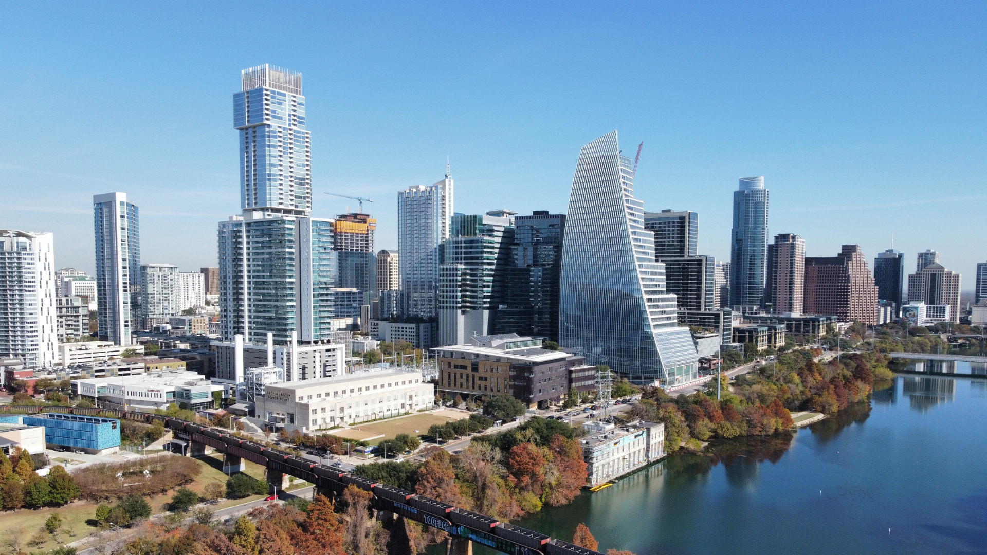 An aerial view of a city skyline with a lake in the foreground.