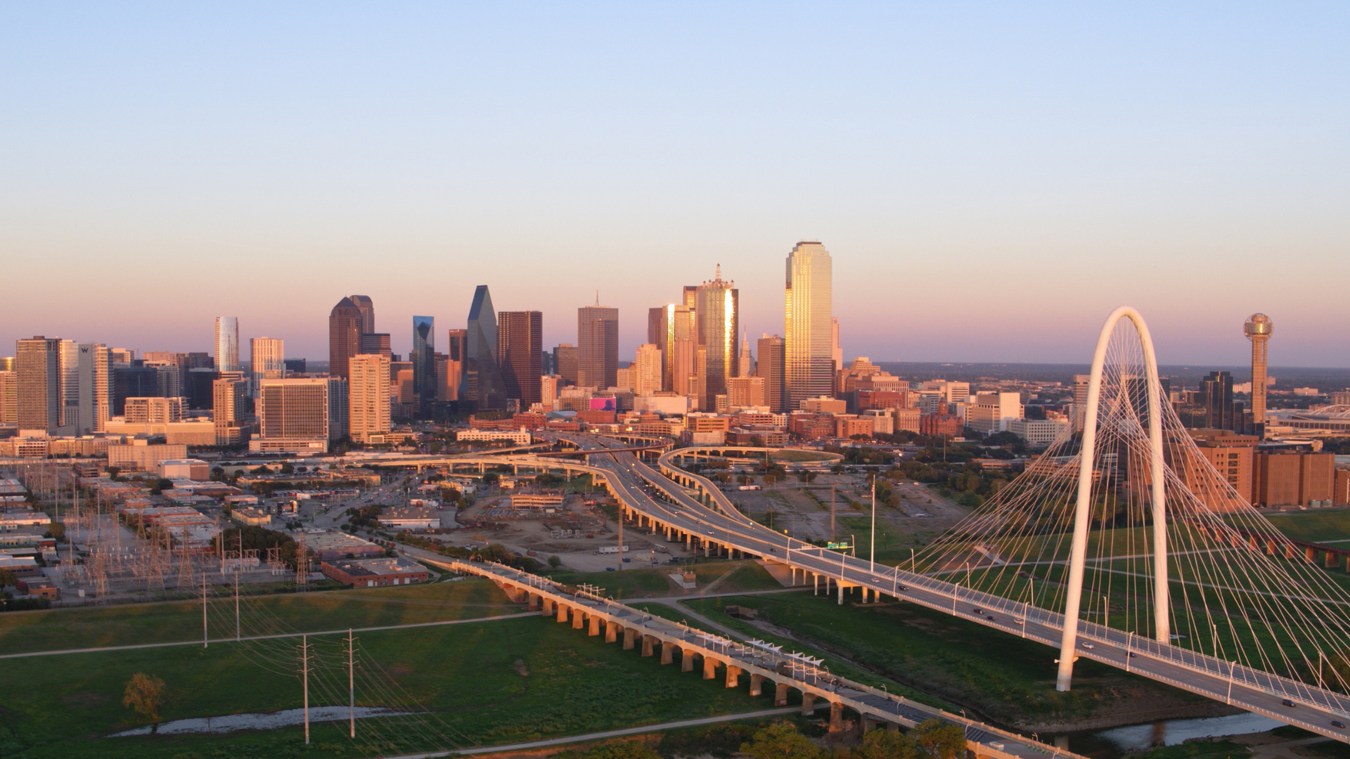 An aerial view of a city skyline with a bridge in the foreground.