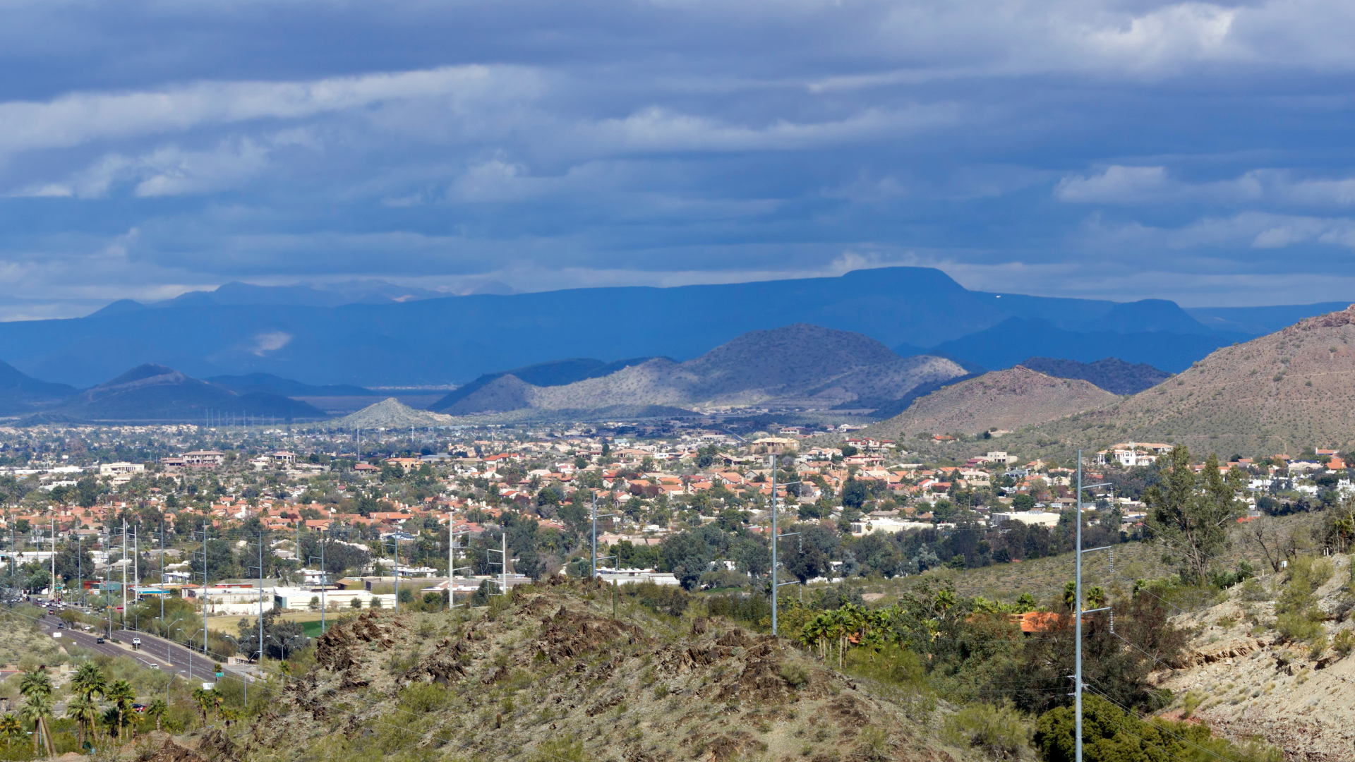 A city in the desert with mountains in the background.