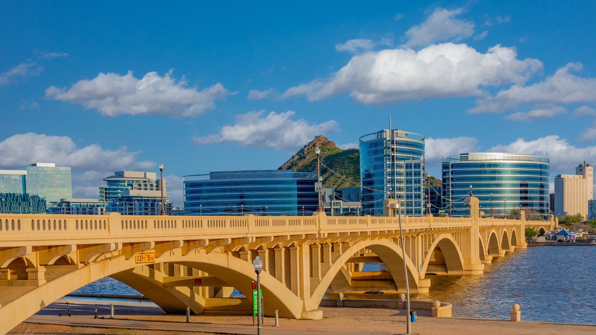 A bridge over a body of water with a city in the background.