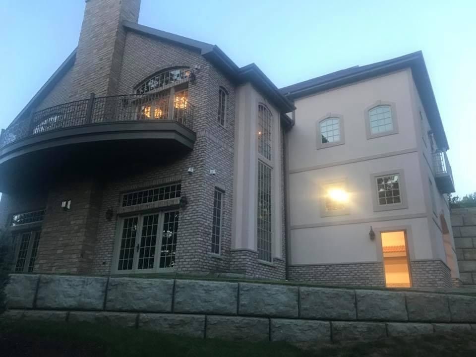 A large brick house with a balcony and a lot of windows.