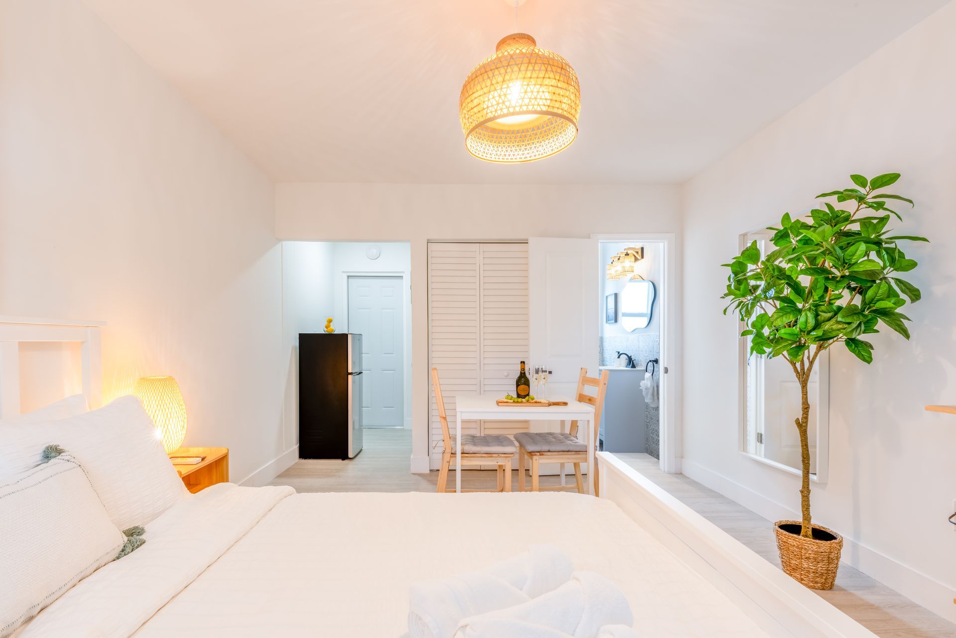 Bright studio apartment with a bed, dining table, and a small kitchen.
