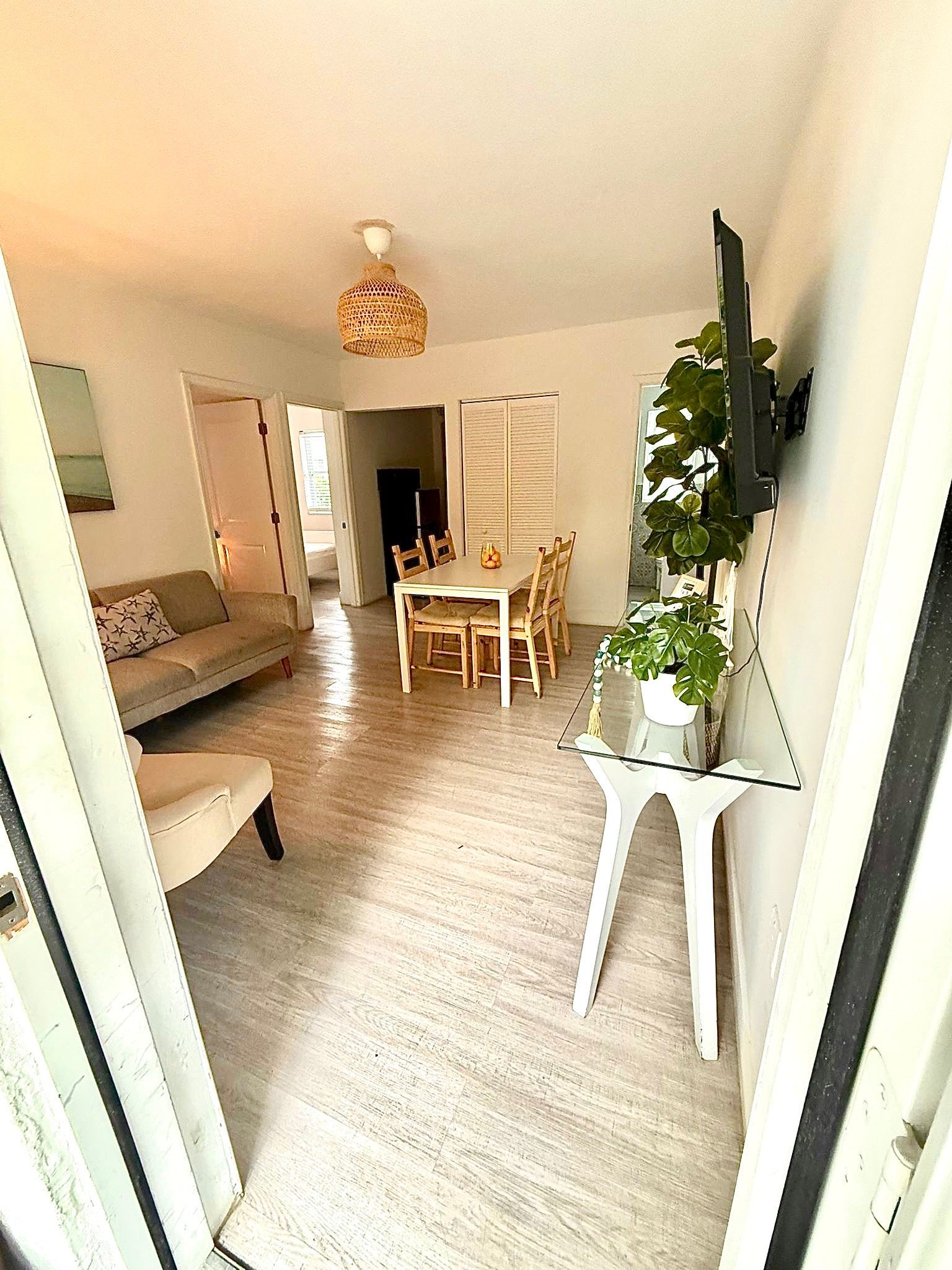 Bright interior: living and dining areas. White walls, light-colored furniture, and a table set for dining.