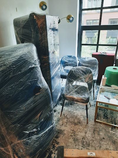 A room filled with furniture wrapped in plastic.