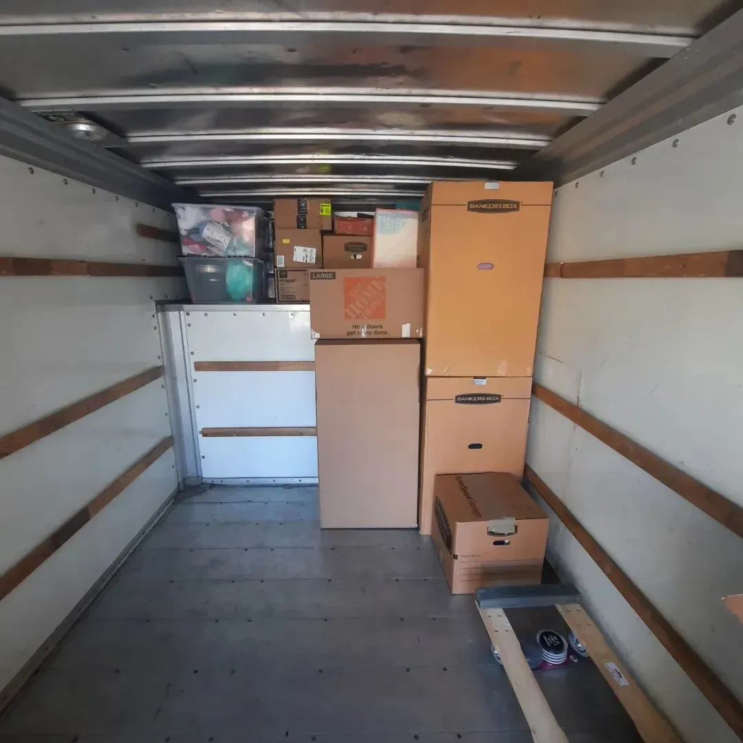 The inside of a moving truck filled with boxes including one that says home depot