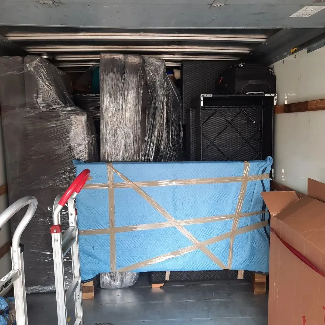 A blue blanket is taped to the back of a moving truck