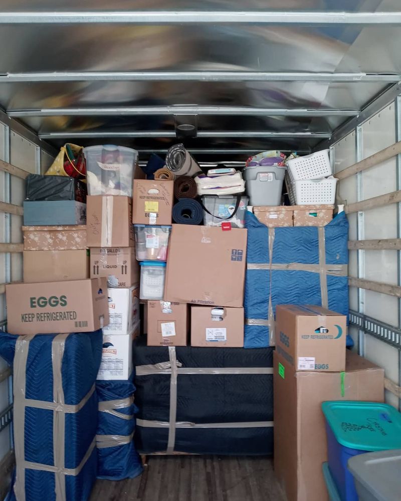 The inside of a moving truck filled with lots of boxes.