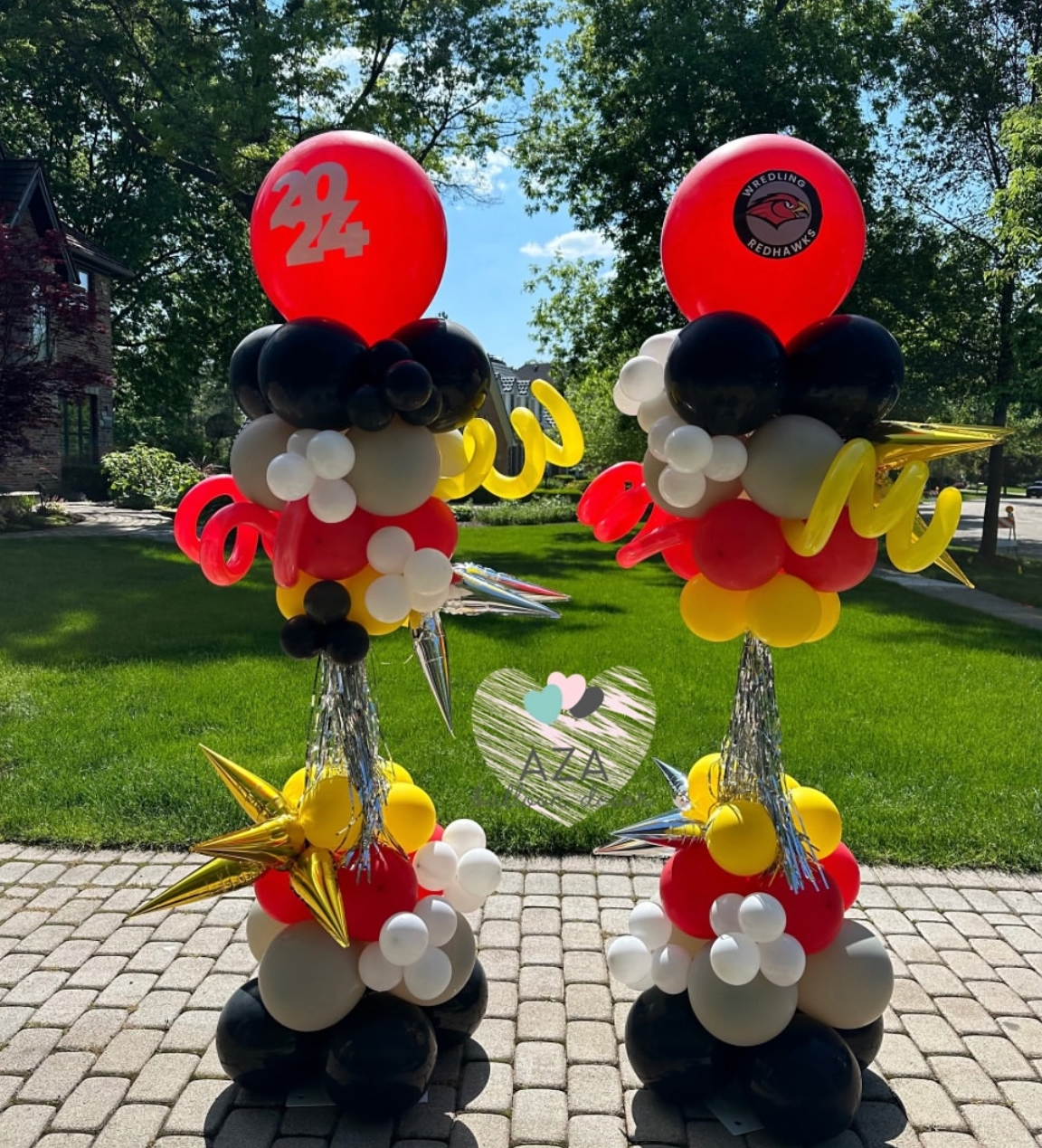 A couple of balloons sitting on top of a brick driveway