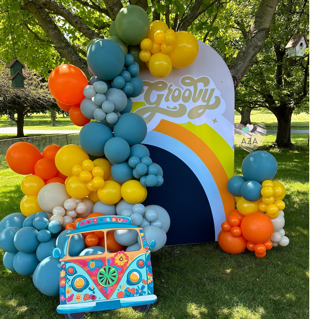 A bunch of pink and purple balloons are hanging on a wall