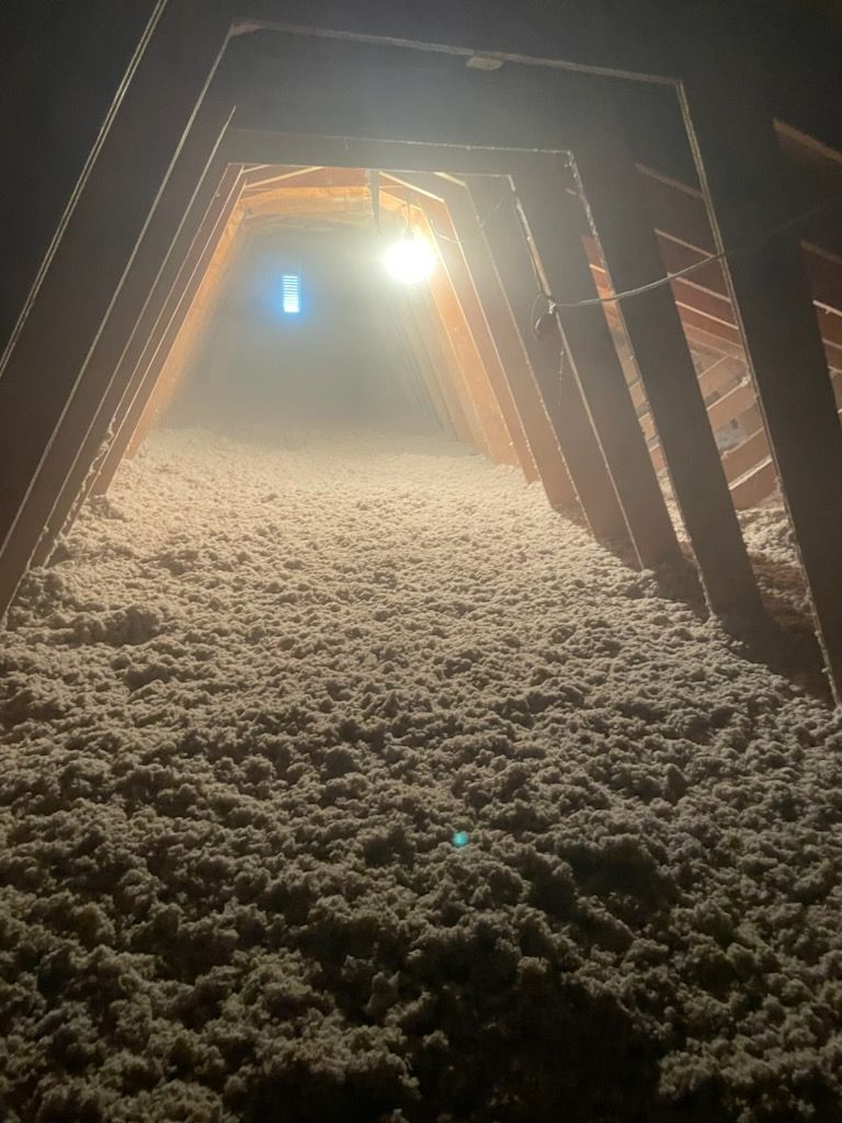 An attic filled with lots of insulation and a light.