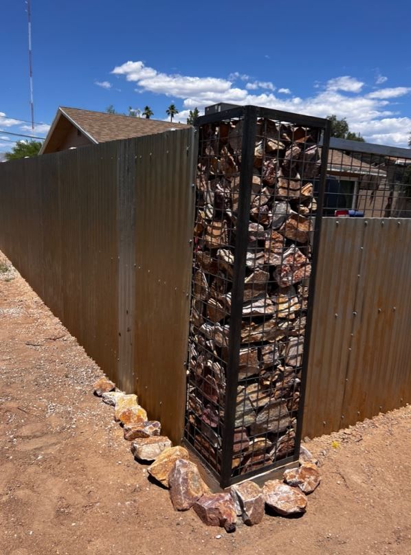 A metal fence with a stone pillar in the middle