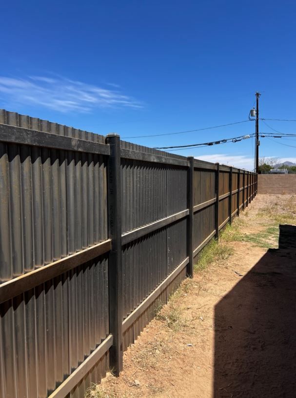 A wooden fence with a blue sky in the background