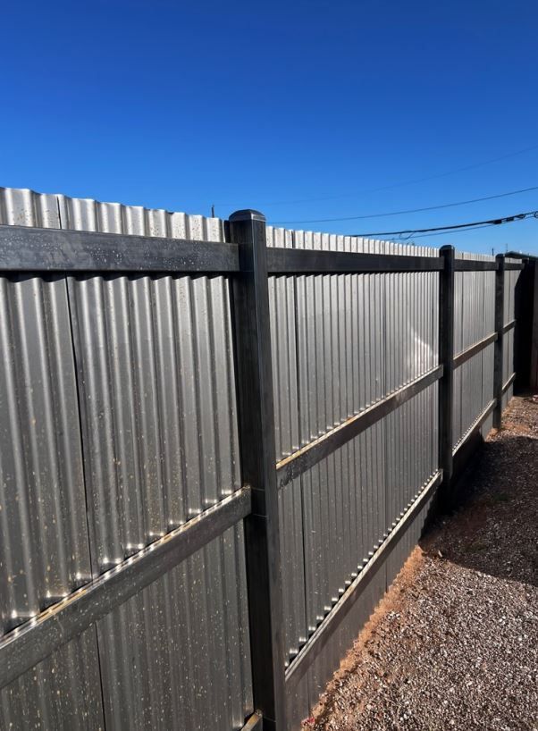 A metal fence with a blue sky in the background