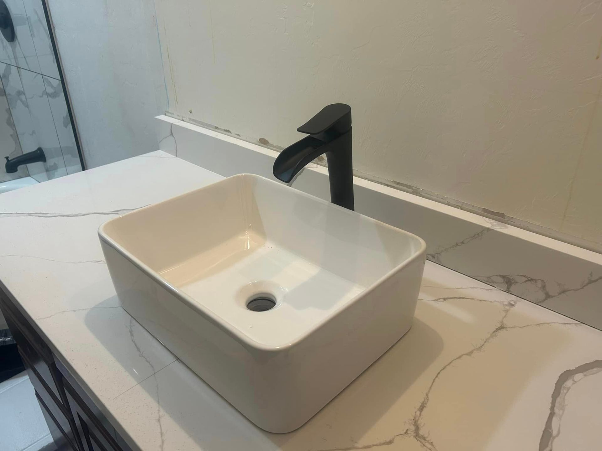 A white sink with a black faucet on a bathroom counter.