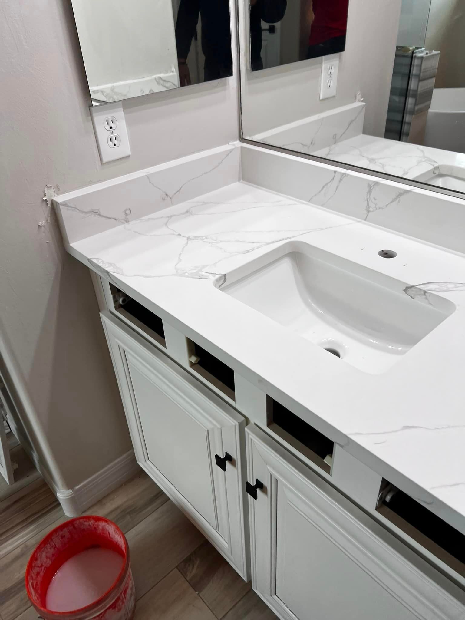 A bathroom with a sink , mirror , and cabinets.