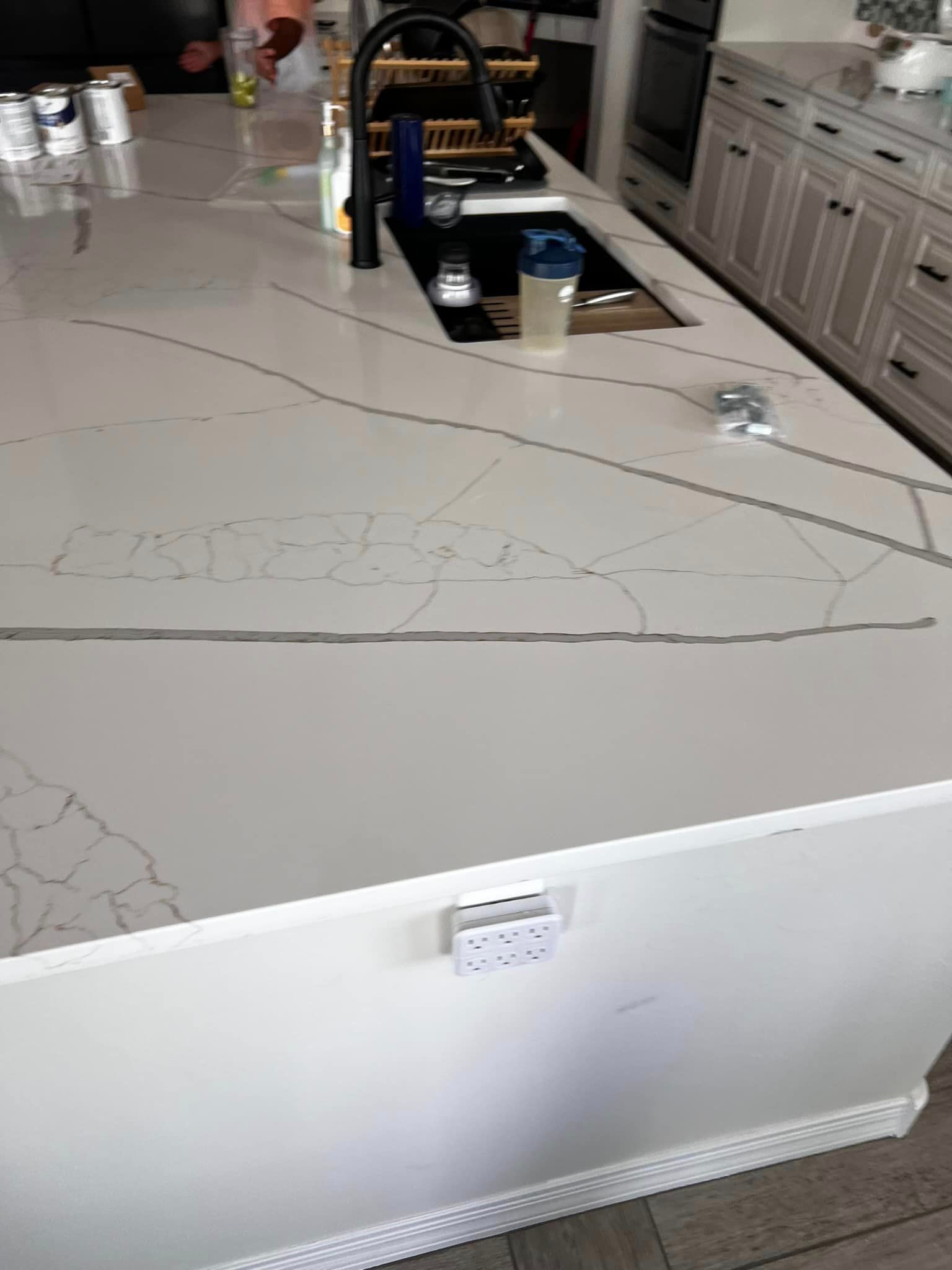 A kitchen with a large island and a sink.