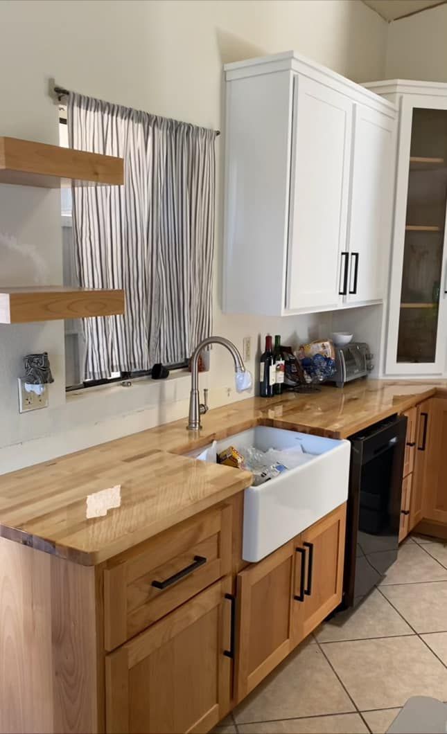 A kitchen with wooden cabinets and a white sink.