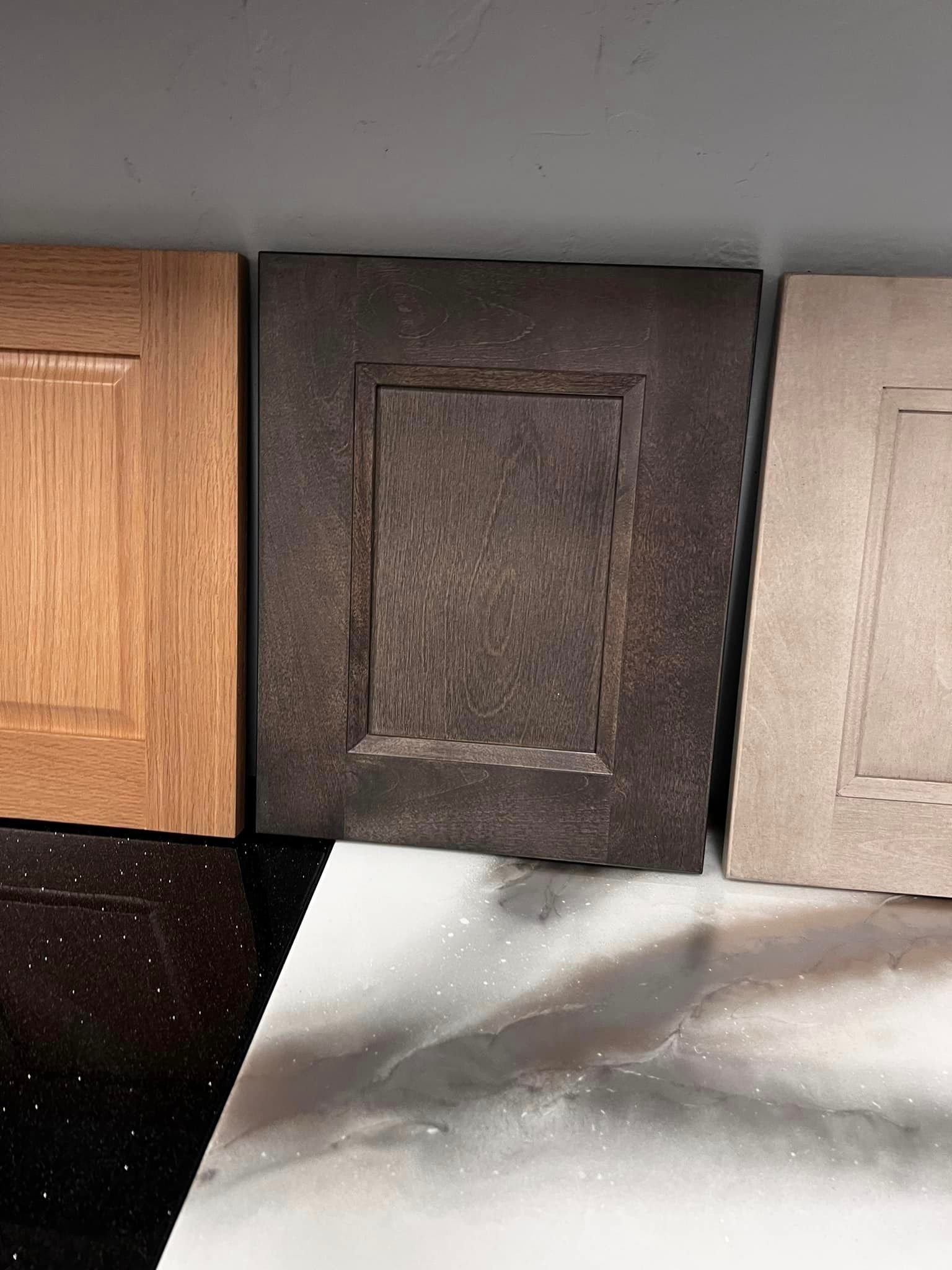Three different types of cabinet doors are sitting next to each other on a counter.