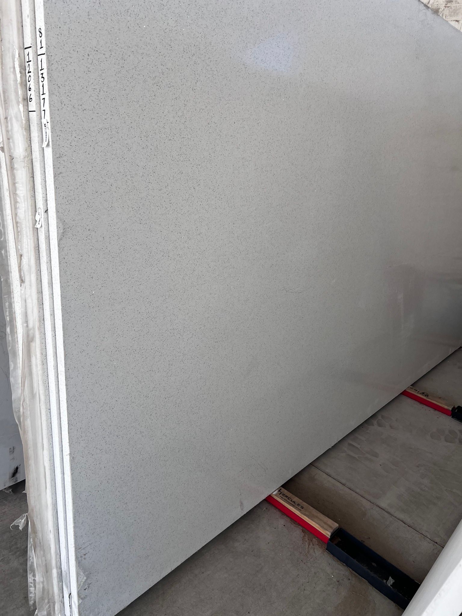 A large white granite slab is sitting on top of a concrete floor.