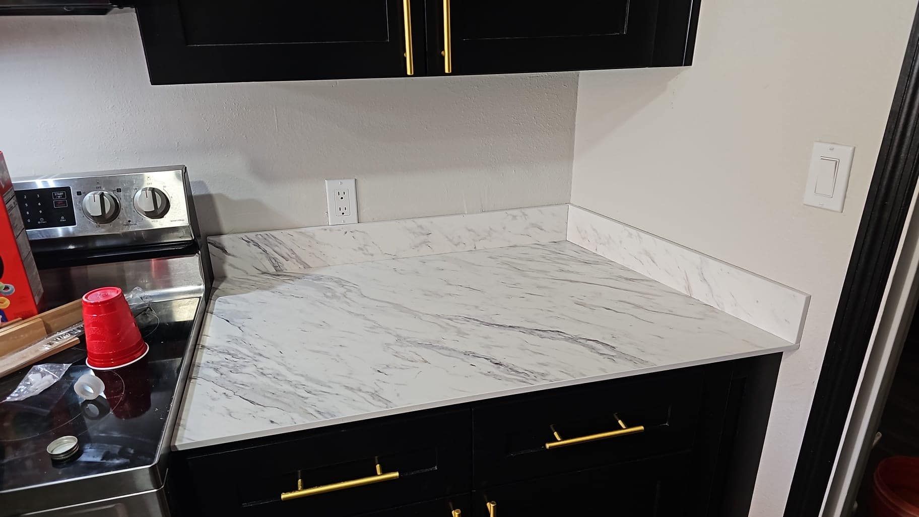 A kitchen with a stove and a red cup on the counter.