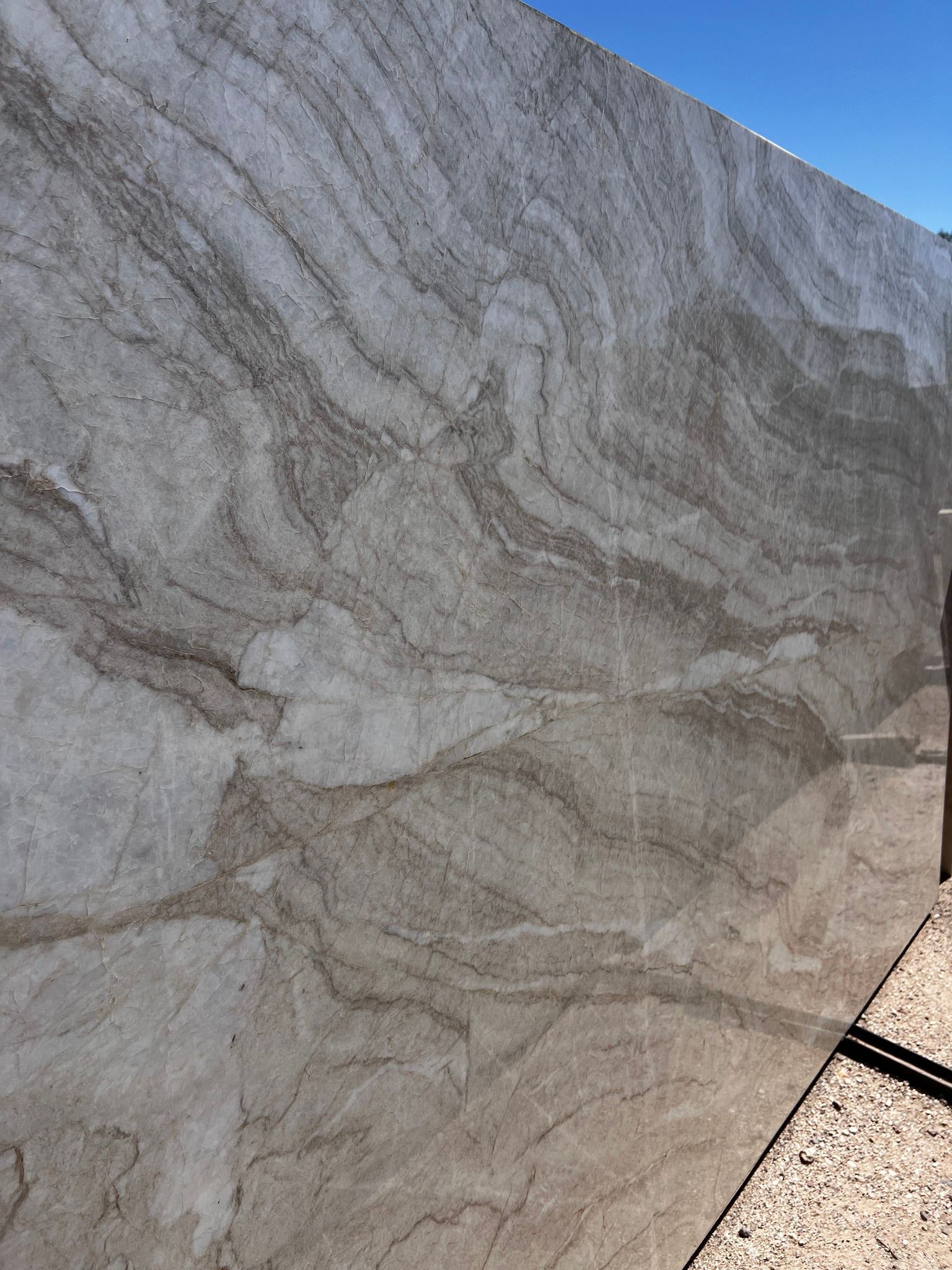 A close up of a marble slab with a blue sky in the background.
