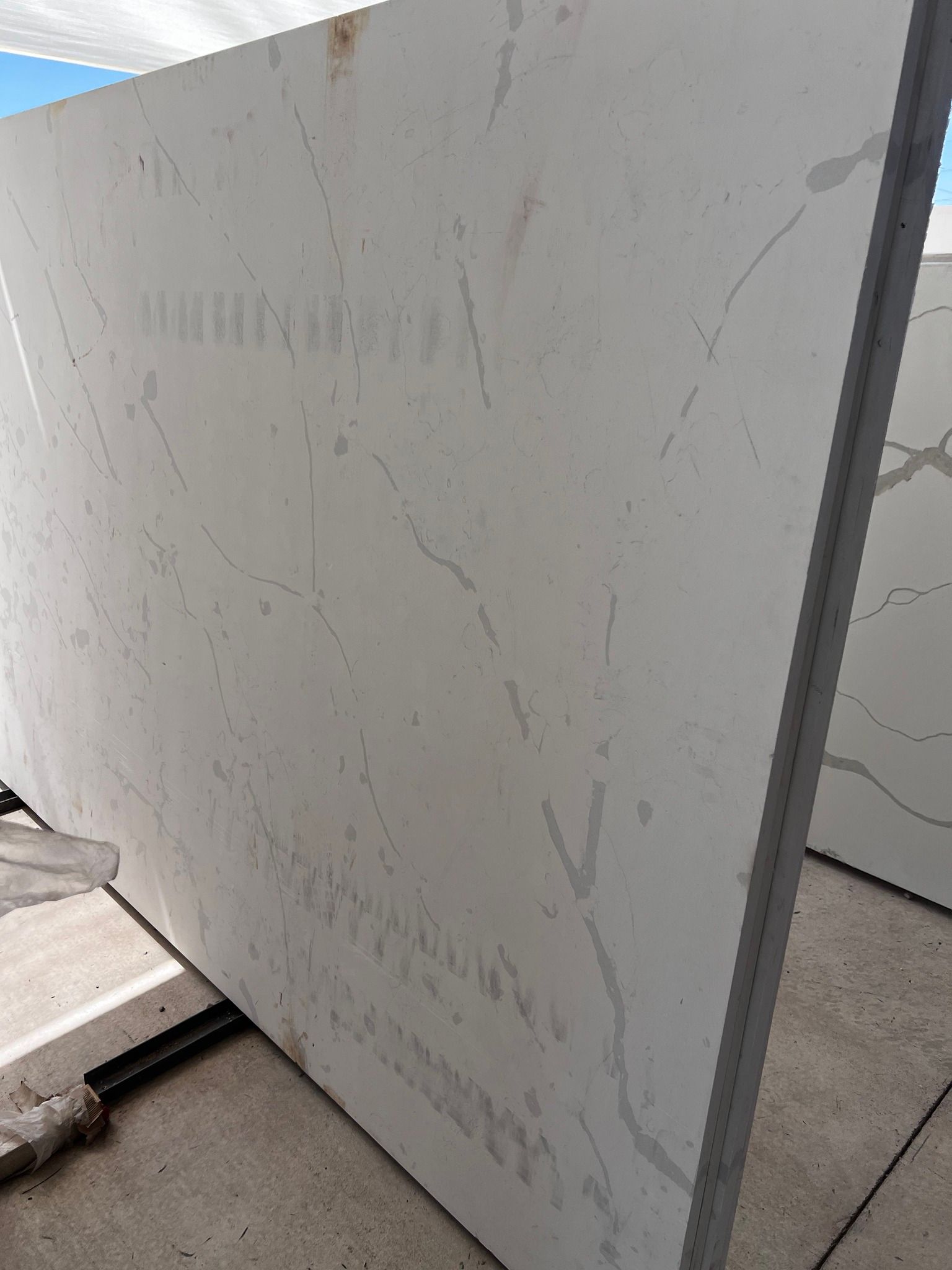 A large white granite slab is sitting on top of a concrete floor.