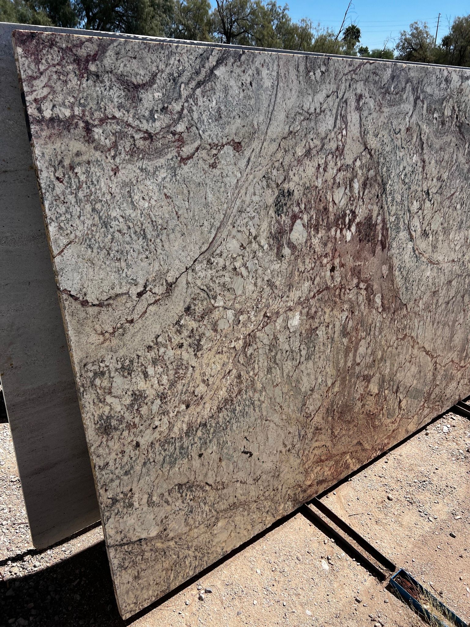 A large slab of granite is sitting on top of a concrete surface.