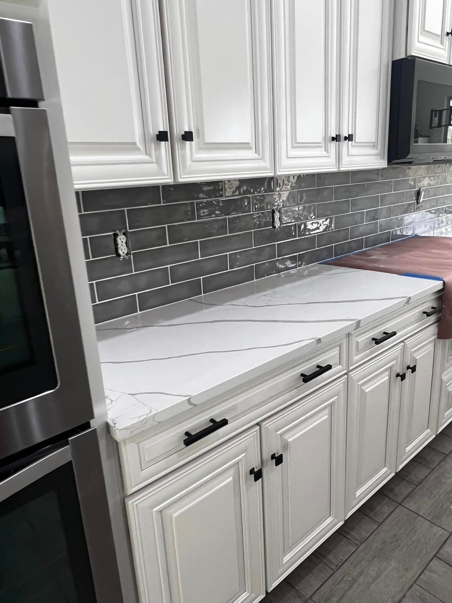 A kitchen with white cabinets and stainless steel appliances.
